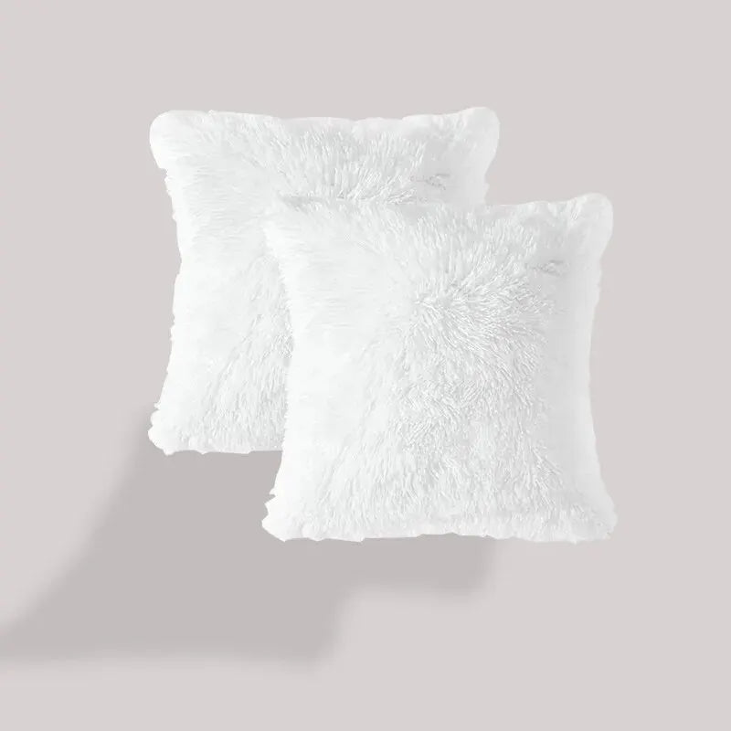 A white, fluffy velvet throw pillow cover is shown against a light gray background.