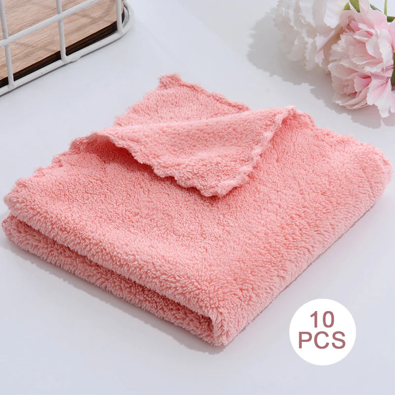 A pile of ten soft, coral pink velvet cleaning face towels are displayed on a white surface.