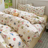 A white floral microfiber duvet set with various patterned pillows and bedding is displayed on a bed.