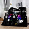 A black and white retro printed flannel throw blanket draped over a white sofa.