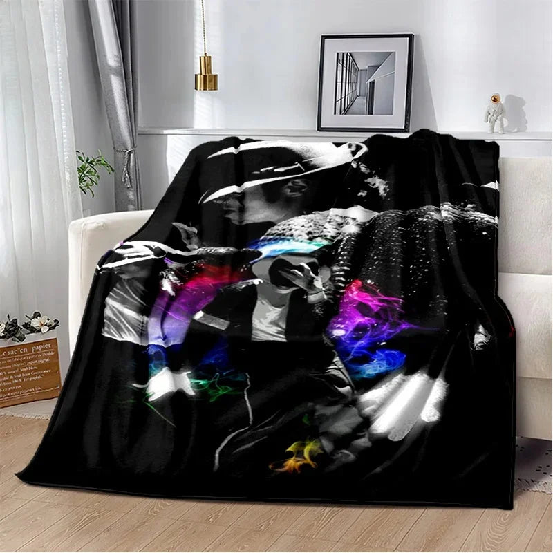 A black and white retro printed flannel throw blanket draped over a white sofa.