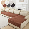 A beige sofa with a brown quilted cushion cover and white decorative pillows.