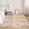 A fluffy cream tie-dye shaggy rug placed on a light wood floor in a bright room.