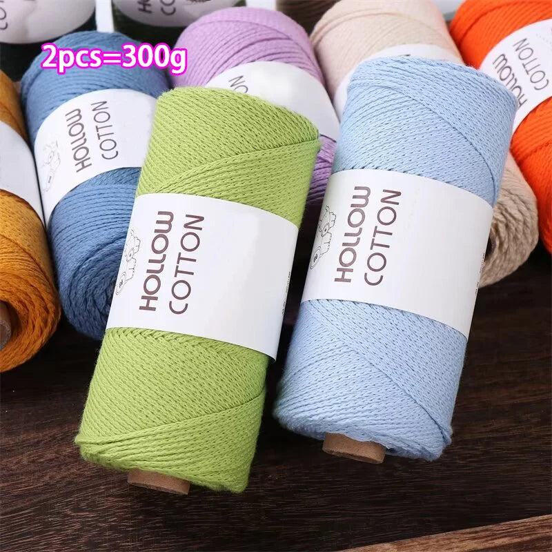 A collection of hand-knitted cotton yarn spools in various shades including blue, green, and orange.