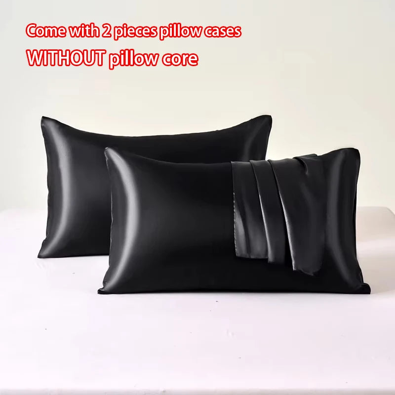 Two black satin pillow cases without a pillow core displayed on a white surface.