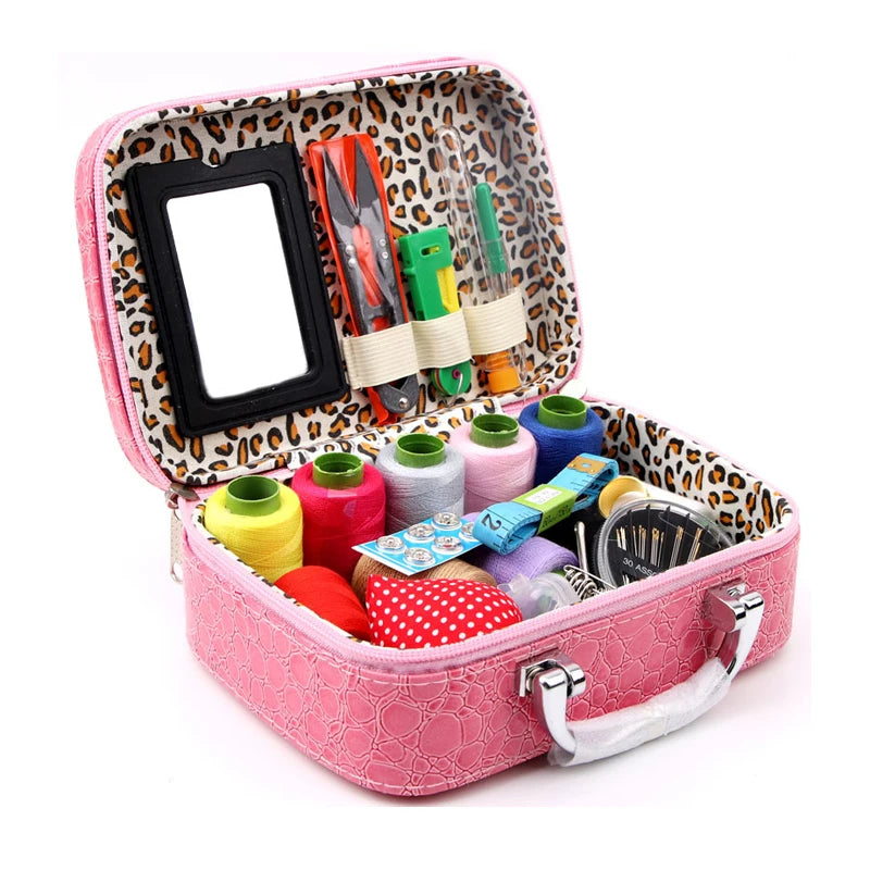 A pink zippered pouch containing a heavy-duty leather sewing kit with various tools and a mirror.