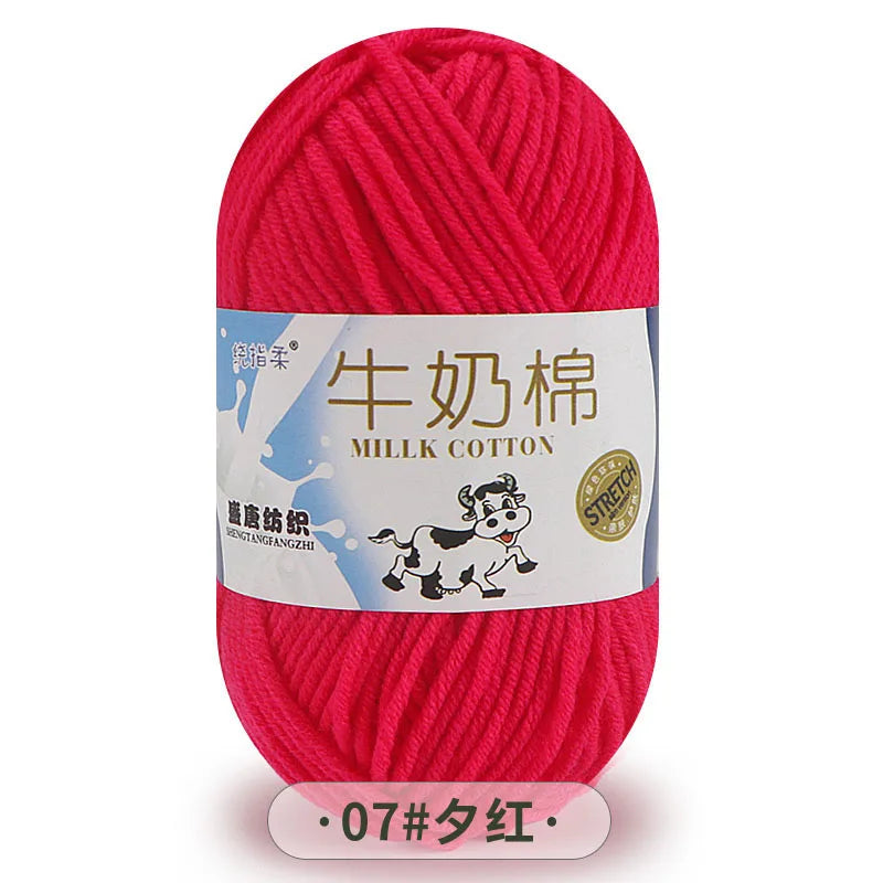 A skein of bright pink milk cotton yarn labeled for knitting
