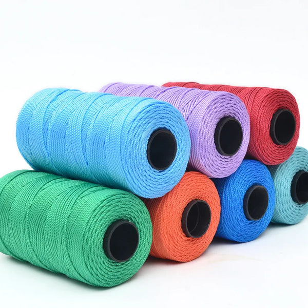 A collection of hand knitting and crochet cord in various colors including blue, purple, red, and green, rolled up for crafti