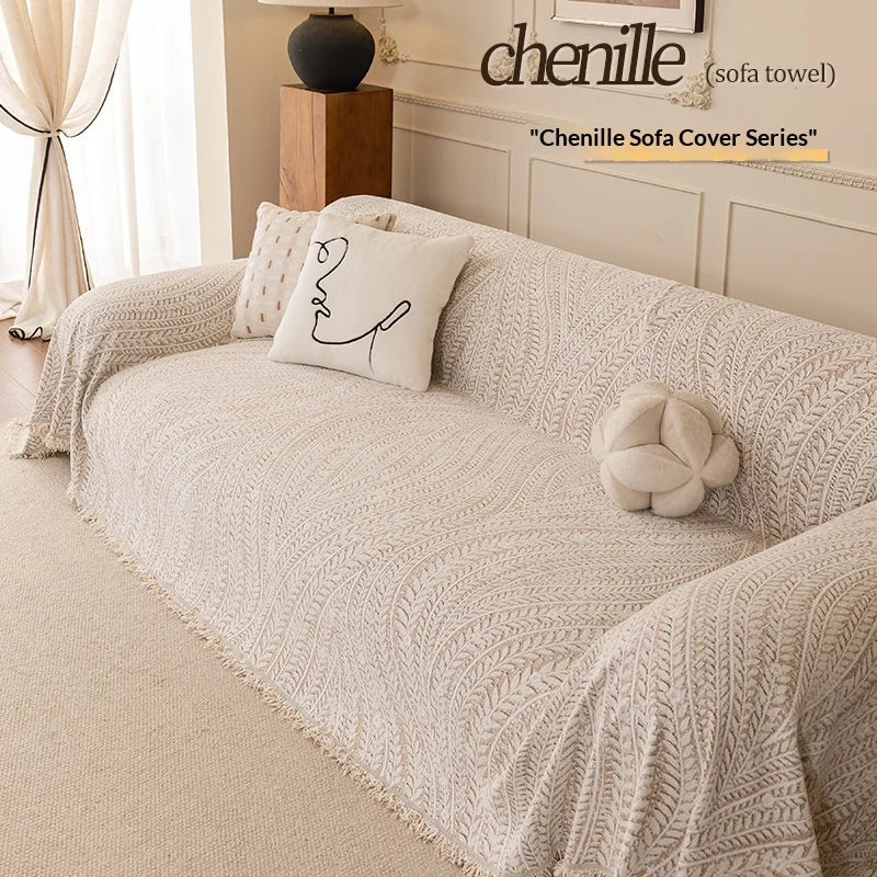 A beige herringbone chenille sofa cover draped elegantly on a light-colored sofa with decorative pillows.
