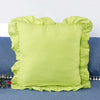 A bright lime green ruffled pillow cover displayed on a blue fabric background.