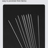 A close-up view of sharp steel sewing needles arranged diagonally against a dark background.