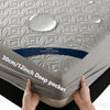 Hands holding a gray quilted mattress protector featuring a healthy sleep label and deep pockets.