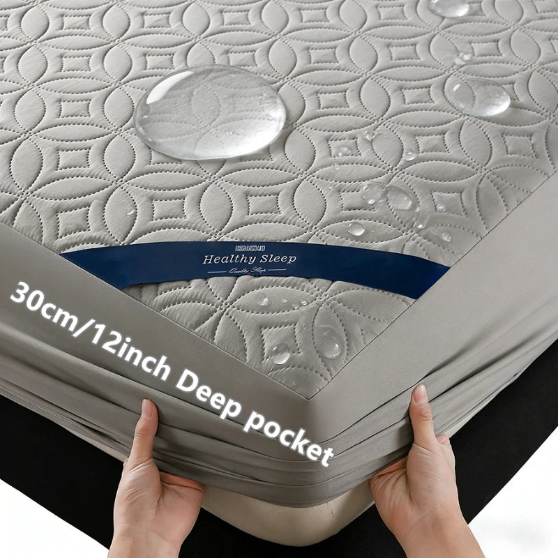 Hands holding a gray quilted mattress protector featuring a healthy sleep label and deep pockets.