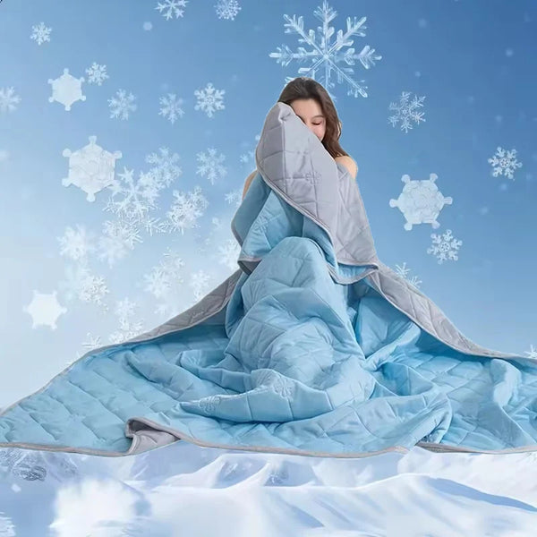 A woman is wrapped in a light blue quilted blanket with a gray lining against a snowy, bright blue background.