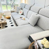 A light gray jacquard elastic sofa slipcover with white decorative pillows and a patterned floor.