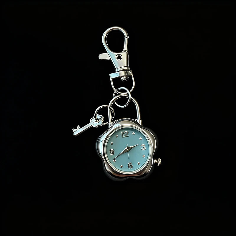 Silver pocket watch keychain featuring a clock face and a small key.