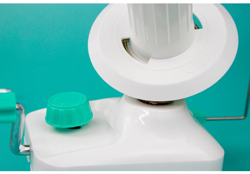 A white hand-operated wool yarn winder device with a green knob is shown against a teal background.