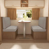 A modern interior showing two upholstered seats with light gray covers and a small table.