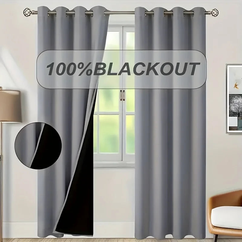 A pair of gray blackout grommet curtains hanging in a window frame.