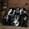 A dark, dramatic photographic print featuring multiple faces in black and white on a blanket.