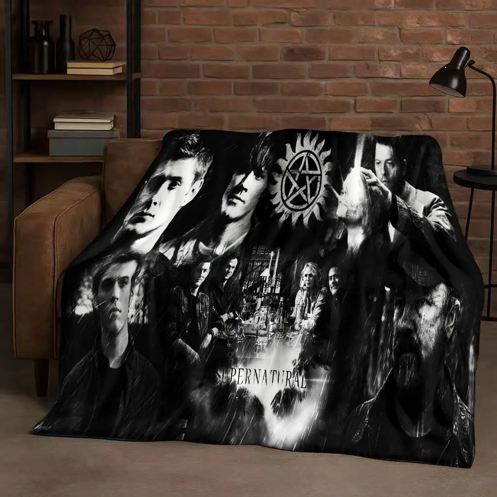 A dark, dramatic photographic print featuring multiple faces in black and white on a blanket.