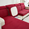 A deep red jacquard elastic sofa cushion slipcover with a white accent panel shown in a modern living room setting.