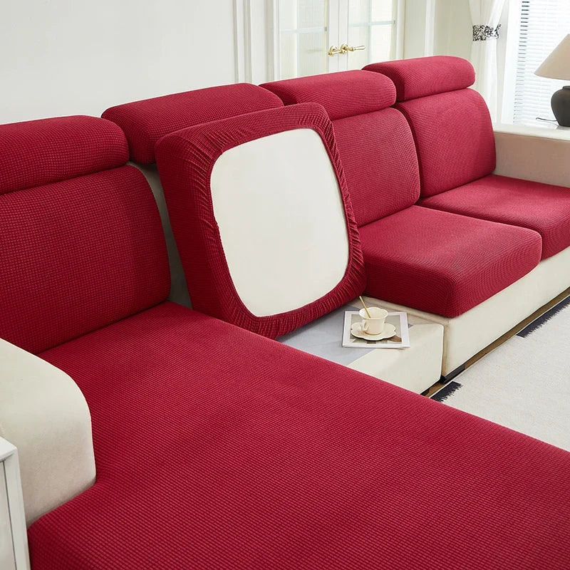 A deep red jacquard elastic sofa cushion slipcover with a white accent panel shown in a modern living room setting.