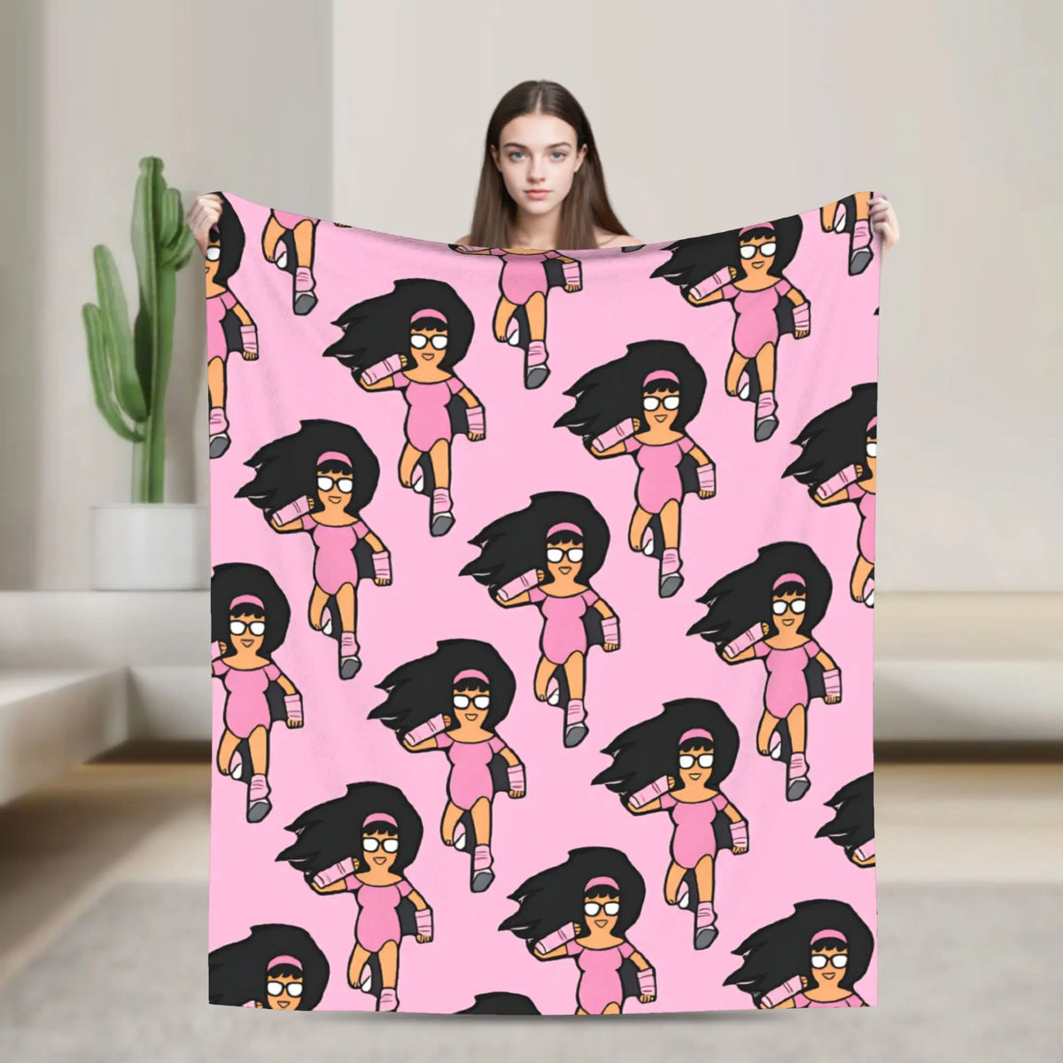 A pink throw blanket featuring multiple stylized anime characters in various poses against a pink background.