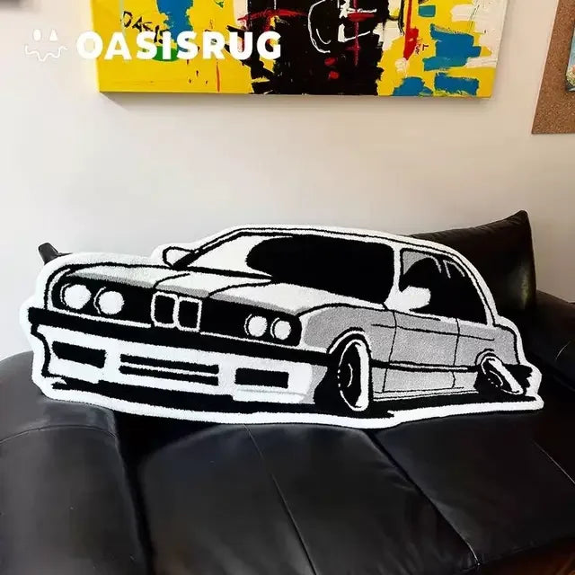 A black and white graphic of a classic car is displayed on a black leather sofa.