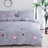 Gray bedding set featuring a pink heart print duvet cover and pillowcases.