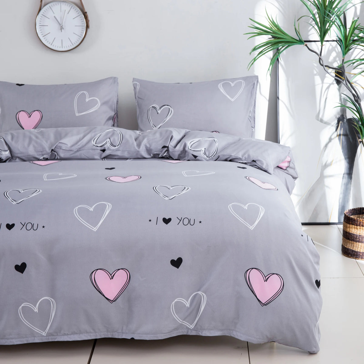 Gray bedding set featuring a pink heart print duvet cover and pillowcases.