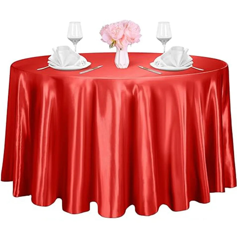 A red satin table overlay set for events featuring glassware and white napkins.