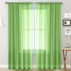 A pair of sheer lime green curtains hanging on a rod, showing a bright window view.