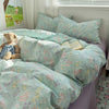 A light mint green floral microfiber duvet set with a teddy bear and a book on a bed.