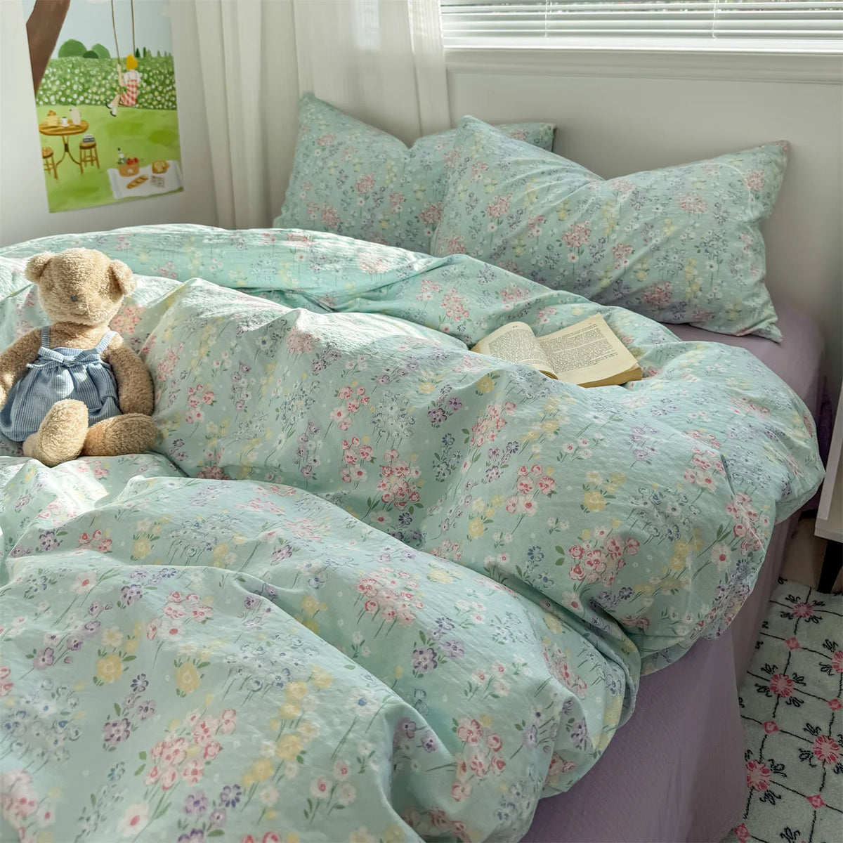 A light mint green floral microfiber duvet set with a teddy bear and a book on a bed.