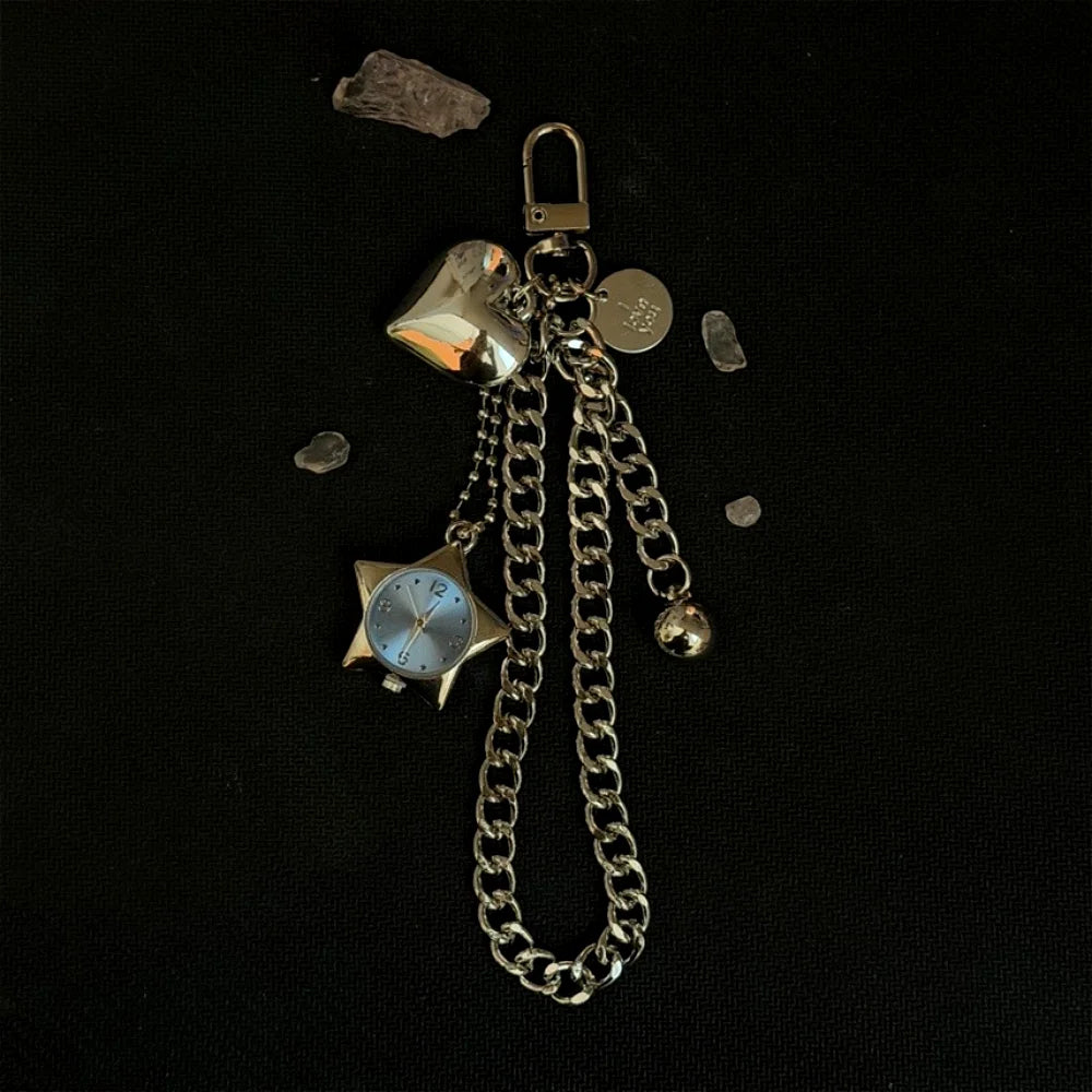Silver star-shaped pocket watch keychain with a chain and a hanging charm on a black background