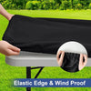 A hand is holding a black elastic edge and wind proof tablecloth over a white table.