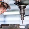 A close-up of a hand operating a machine, working with a galvanized steel cotter pin assortment and R-clips.