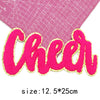 Pink felt cheer letter patch with gold glitter outline on a pink grid background