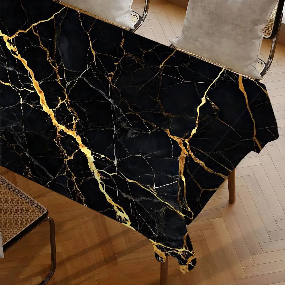 Black marble table cloth with gold veining draped over a wooden table.