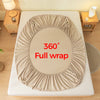 A beige fitted sheet is shown fully wrapped around a mattress, demonstrating a 360 degree coverage.