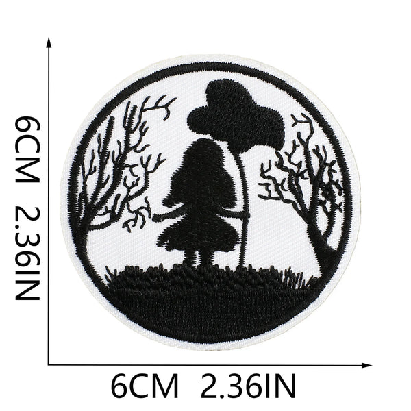 Black embroidered patch featuring a silhouette of a tree and a small figure on a white background