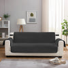 A modern gray reversible sofa slipcover placed in a bright living room setting.