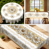 Elegant floral tablecloth with embossed edges featuring white and gold flowers on a wooden table.