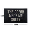 Black embroidered patch with white text that reads The Ocean Made Me Salty