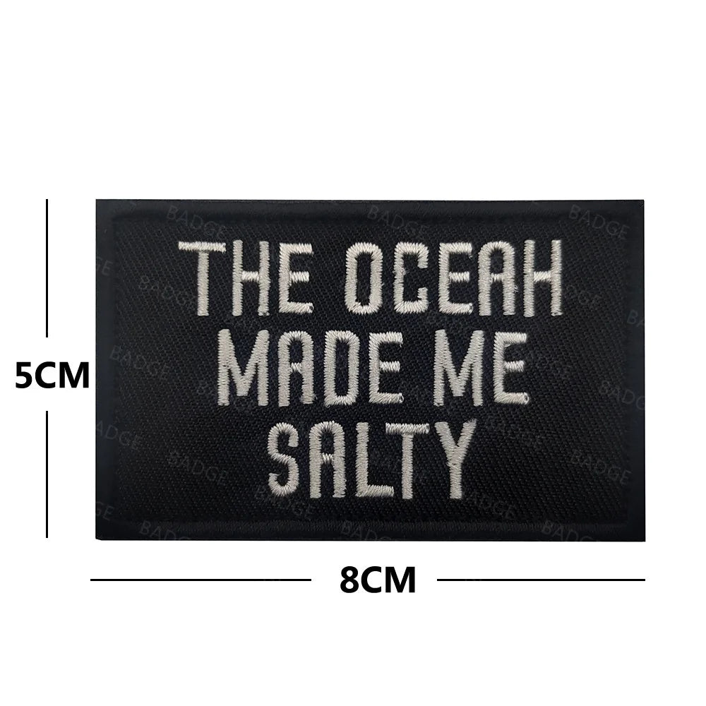 Black embroidered patch with white text that reads The Ocean Made Me Salty