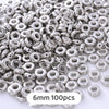 A pile of silver metallic geometric beads for jewelry making