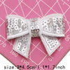 Silver sequin bow patches for DIY decoration shown on a pink background with a ruler.