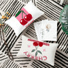 A set of chibi anime cartoon cushion covers featuring cherry designs on a black and white striped background.