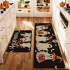 A black non-slip kitchen rug featuring Halloween ghost and pumpkin prints placed on a wooden floor.